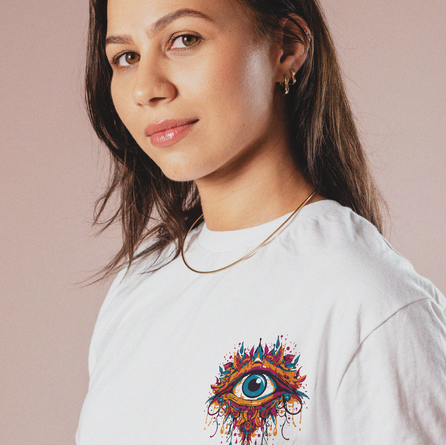 A lady wearing the All Seeing Eye tee. She is looking into the camera, and wearing a gold necklace.